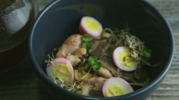 Se centran en el plato de fideos con hongos shiitake, huevos cocidos y jarra con caldo — Vídeo de stock