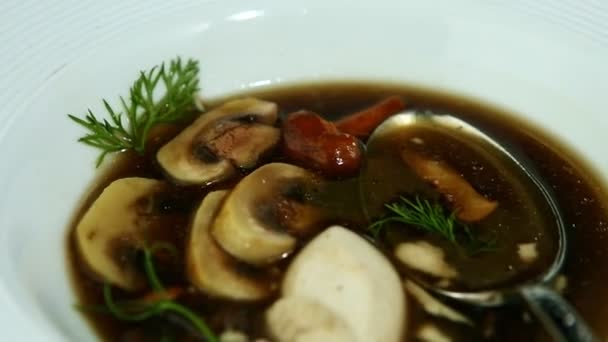 Closeup deep white plate with mushroom soup put on black table — Stok video