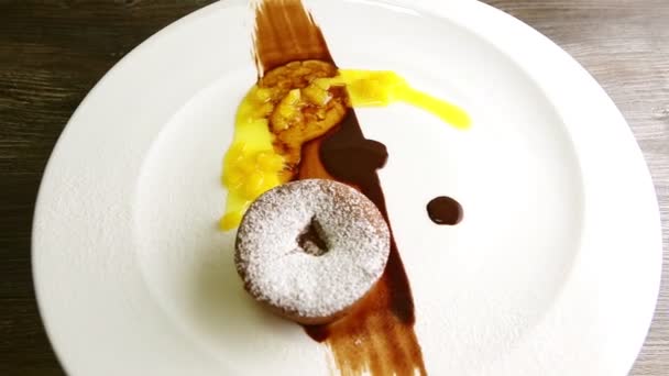 Zoom lent à sucre en poudre petit gâteau au chocolat tourne sur plaque — Video