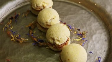 closeup finely decorated four spherical sponge biscuits spinning on plate