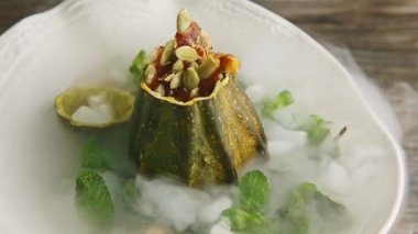 zoom out from pumpkin dessert decorated with white smoke rotates on white plate