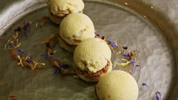 Closeup finely decorated four spherical sponge biscuits spinning on plate — Stockvideo