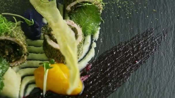 Closeup αρχικά διακοσμημένα ψάρια ρολά με σάλτσες κλώση σε μαύρο πιάτο — Αρχείο Βίντεο