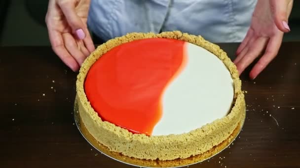 Vrouw handen duwen versierde ronde cheesecake naast plaat met verse aardbeien — Stockvideo