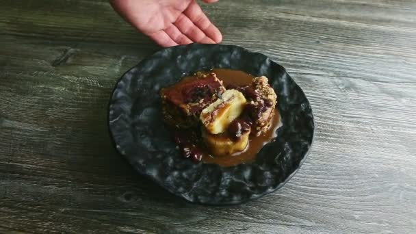 Mano humana rota plato negro con filete de carne finamente decorado — Vídeos de Stock