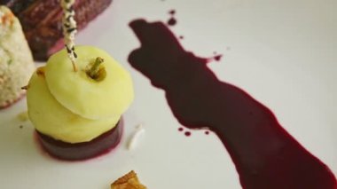 Yakın plan dekore edilmiş et lokantası yemekleri beyaz tabakta dönüyor.