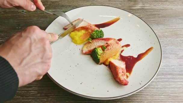 Человеческие руки отрезали кусок жареной курицы с коричневым соусом — стоковое видео