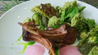 Enfes dekore edilmiş yeşil sebzeli ızgara pirzola üzerine yakın çekim panoraması.