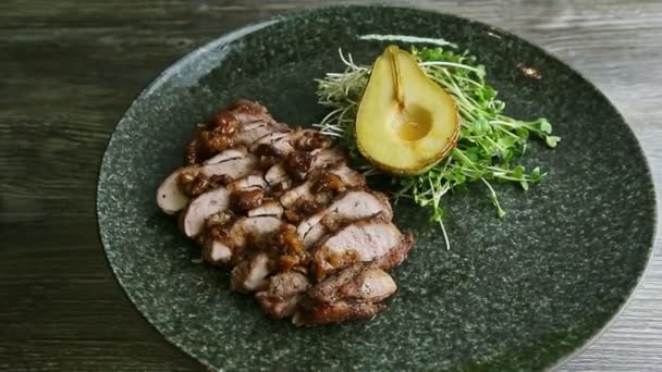 Zoom lento en exquisito plato decorado de rebanadas de carne asada gira en plato negro — Vídeo de stock