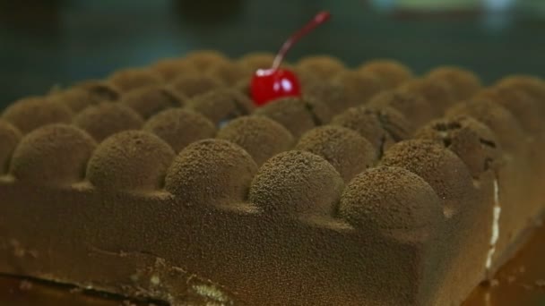 Closeup woman hand takes away half of modern shaped creamy chocolate cake — Stok video