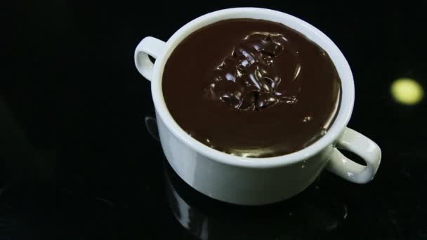 Vista superior primer plano en gran taza redonda blanca con chocolate negro derretido — Vídeos de Stock