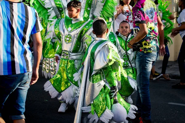 Gruppo di piccoli ragazzi in costumi luminosi passano sulla strada della città al carnevale dominicano — Foto Stock