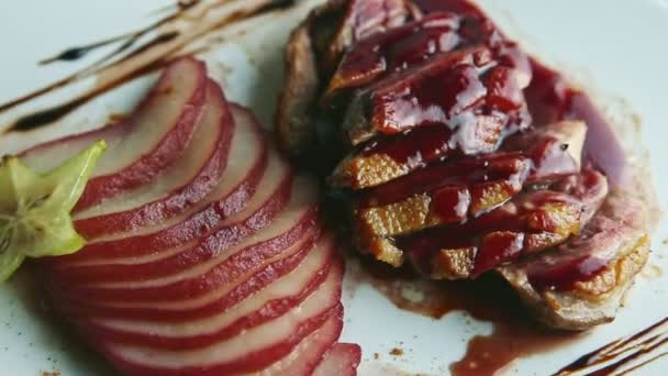 Closeup exclusive decorated sliced baked duck breast rotates on plate — Stock video