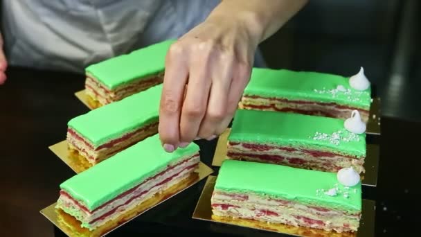 Process of decorating green glazed cake portions by white crashed bizet — Stockvideo