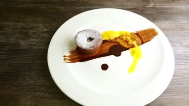 human hands want to cut sugar powdered chocolate cake by knife