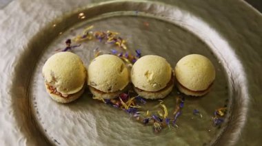 closeup modernly decorated four spherical sponge biscuits spinning on plate