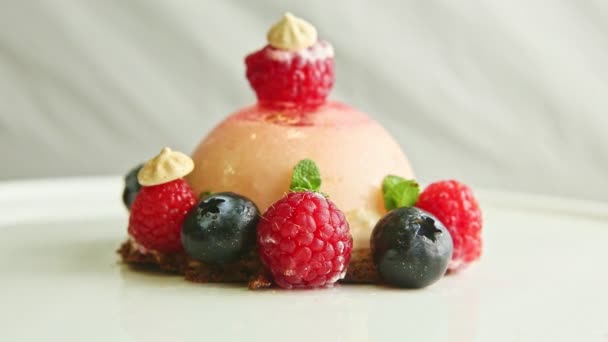 Closeup icing dessert exclusive decorated with berries rotates on plate — ストック動画