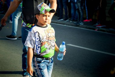 Concepcion De La Vega, DOMINICAN REPUBLIC - FEBRUARY 09, 2020: small girl in variegated costume passes by city street at dominican annual carnival on February 9 in Concepcion De La Vega