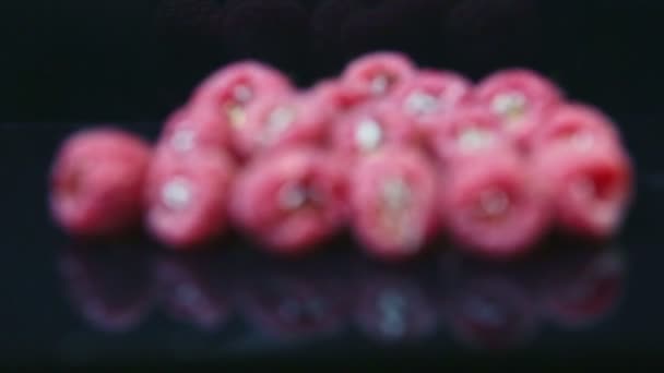 Focus in at group of ripe fresh raspberries stuffed with jelly served on black surface — 图库视频影像