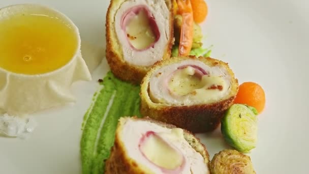 Macro view at sliced chicken cutlets with grilled vegetables rotates on plate — 图库视频影像