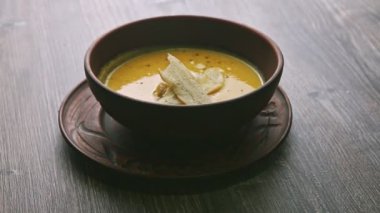 panorama down on yellow cream soup decorated with mushrooms and dried bread