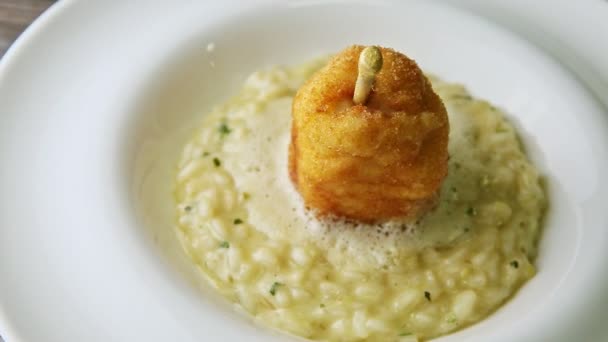 Top view closeup breaded whole pear on boiled barley porridge rotates on white plate — Stok video