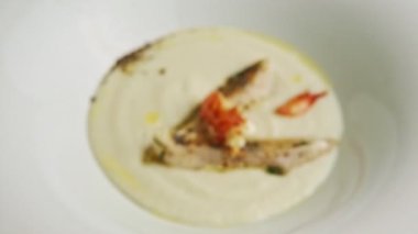 closeup focus in at delicious white cream soup with prawns and fried fish pieces