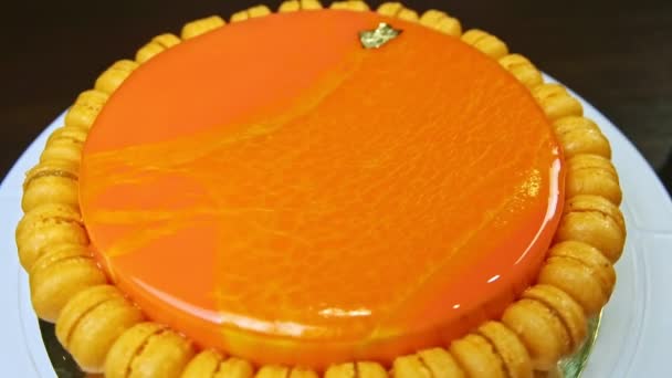 Top view on whole round cheesecake decorated with mini macaroons rotates around — Stock video