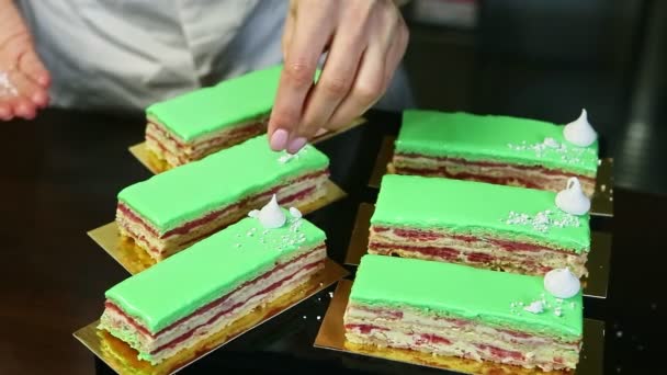 Processo di decorazione di pezzi di torta stratificati con bizet bianco da mani di pasticceri — Video Stock