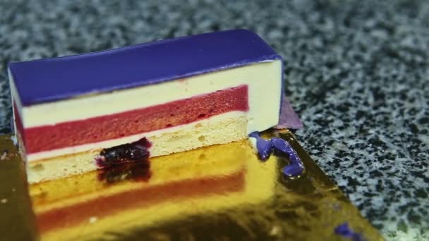 Céntrate en el pedazo de pastel de queso esmaltado violeta con capa intermedia de gelatina de bayas rojas — Vídeo de stock