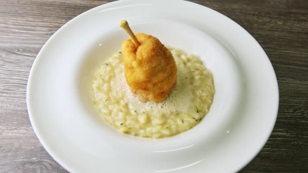 Top view on breaded whole pear on boiled barley porridge rotates on white plate — ストック動画