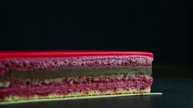 closeup panorama on portion of pink glazed multi-layered chocolate cake
