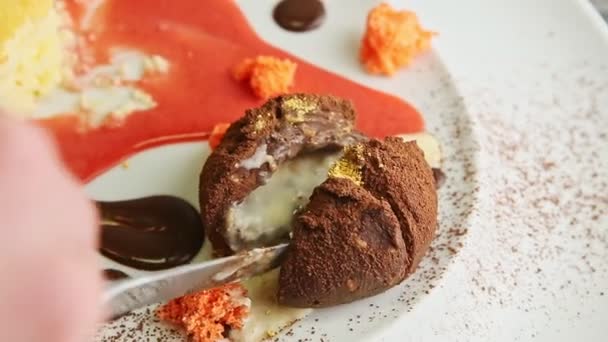 사람의 손을 감싼 클로즈업 초콜릿 디저트를 칼로 썰어 놓은 모습 — 비디오