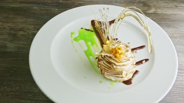 Fijn versierd gebakken zwaanvormig dessert ronddraaiend op bord — Stockvideo