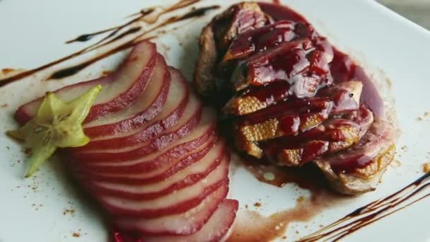 Slow zoom in at finely decorated fried sliced duck breast rotates around — Stock Video