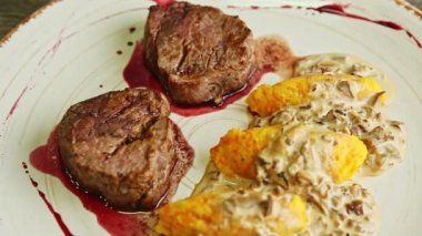 Sos ve patates garnitürlü iki kızarmış et üzerine yakın plan panorama.