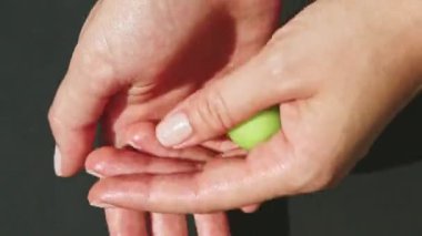 Üst kattaki kadın elleri yeşil badem ezmesi kütleli küçük yuvarlak bir parça serer.