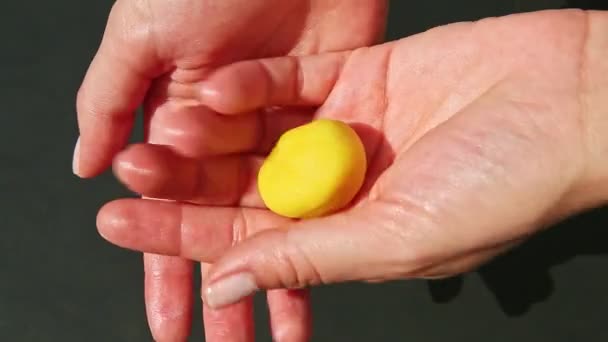 Vue de dessus sur les mains de la femme forme des bonbons en forme de citron de la masse de massepain jaune — Video