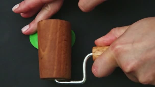 Top view closeup hands roll out small piece of green marzipan mass by wooden roll — Stock Video