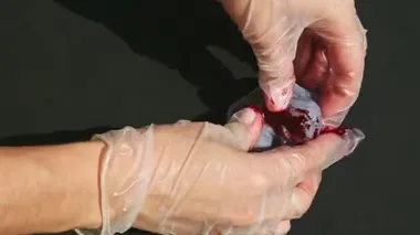 Ellerdeki üst görünüm mor badem ezmesi parçasına kırmızı renk katar ve yoğurur