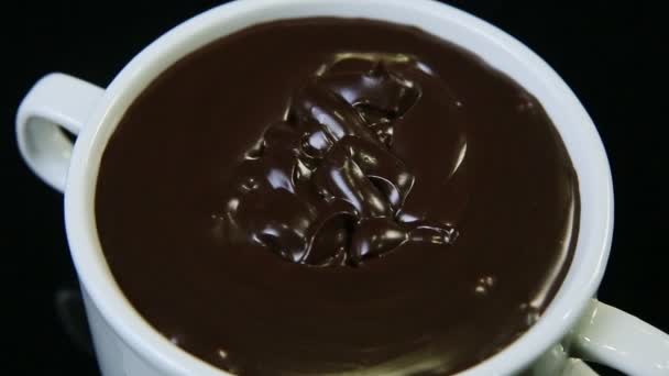 Top view closeup melted dark chocolate served in big white round cup — Stock Video