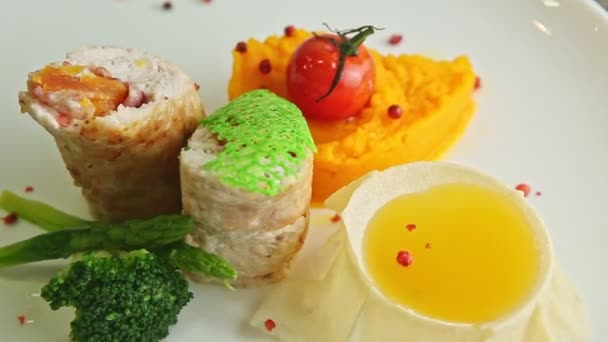 Nahaufnahme exquisit dekorierte gefüllte Hühnerrolle dreht sich auf weißem Teller — Stockvideo