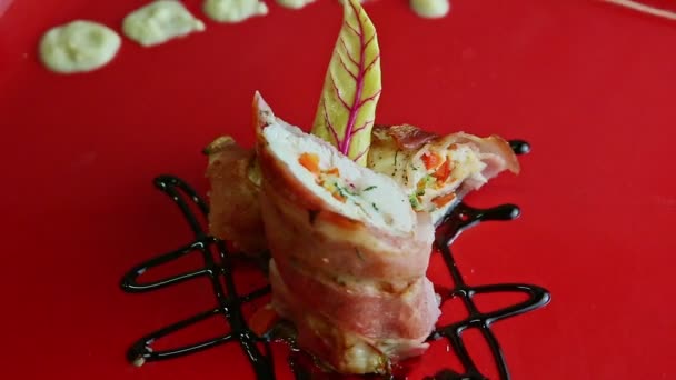 Зум из вкусного мясного рулета, запеченного в беконе, вращается на квадратной тарелке — стоковое видео