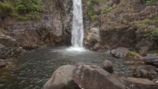 Cascada înaltă curge în râu printre băncile stâncoase — Videoclip de stoc