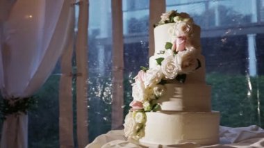 panorama right on beautiful four-tiered wedding cake with big roses