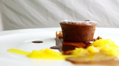 closeup one half of chocolate cake with assorted syrups rotates on plate