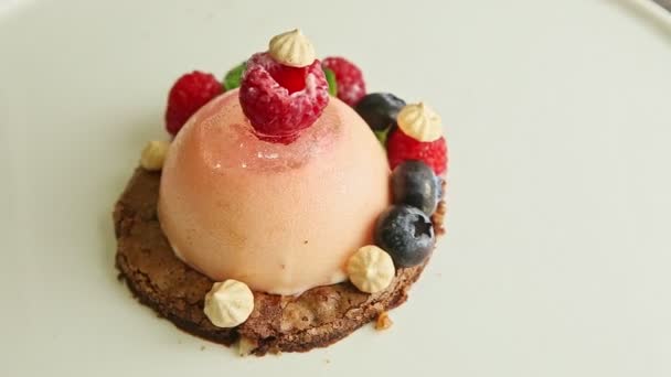 Zoom out from dessert trendy decorated with berries rotates on plate — Stok video