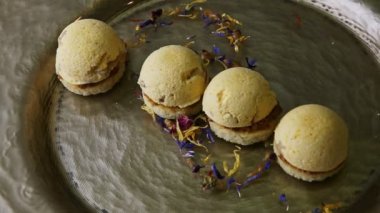 top view closeup finely decorated four spherical sponge biscuits on golden plate