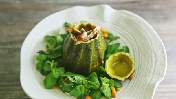 Modern pumpkin dessert finely decorated with fresh mint rotates on white plate — Stockvideo