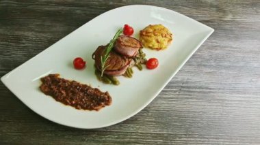 slow panorama on white restaurant dish with grilled meat